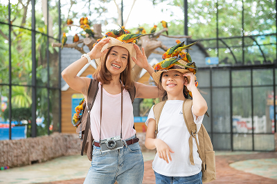Cute Child Feeling Happy Smiles With Her Mother While Playing With Parrot Bird