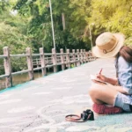 Woman Writing Book While Sitting Footbridge Lake 1 week in Thailand