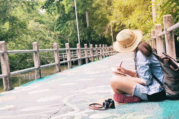 Woman Writing Book While Sitting Footbridge Lake 1 week in Thailand